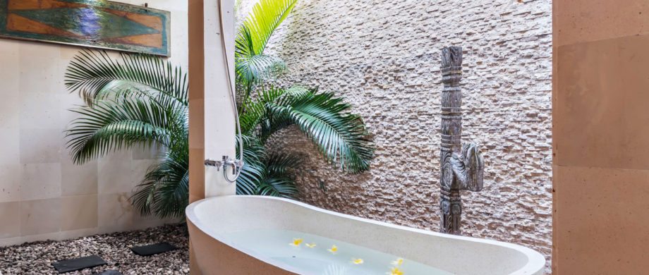 Banheira externa privativa com palmeiras e flores em Villa Saraswati em Citakara Sari Estate