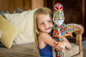 Bambino che tiene la bambola balinese in vacanza a Bali a Citakara Sari Estate