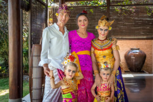 Eine Familie, die balinesische Kostüme und Kunst während eines Citakara Sari Estate Urlaub genießt