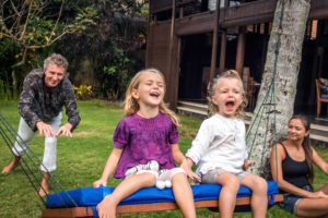 Eine Familie, die Spaß auf einer Schaukel im Citakara Sari Estate hat